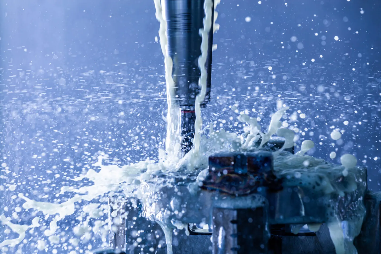 CNC Milling process shown with vertical cnc steel mill hydraulic clamping chuck with external water coolant streams and splashes